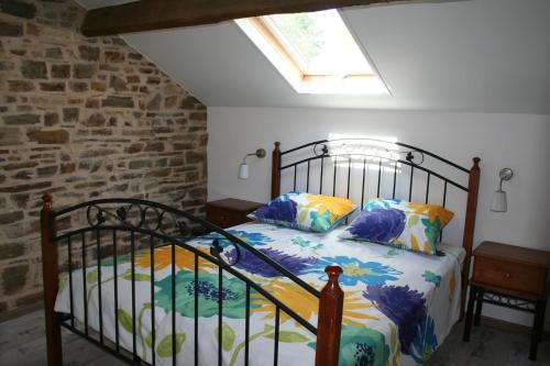 een slaapkamer met een bed in een kamer met een raam bij Liabaquet Gîtes in Sarlande
