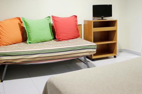 a couch with colorful pillows on it in a room at El Jardi in Barcelona