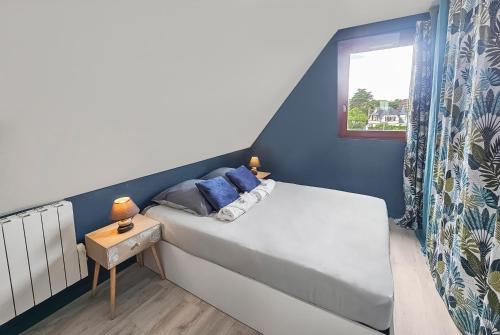 um pequeno quarto com uma cama e uma janela em F2 cosy avec balcon em Merville-Franceville-Plage