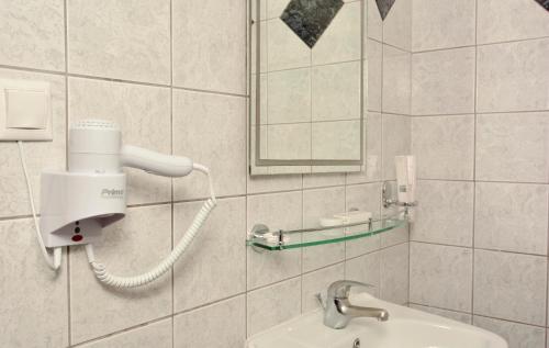 uma casa de banho com um lavatório e um secador de cabelo em Grand Platon Hotel em Olympiakí Aktí