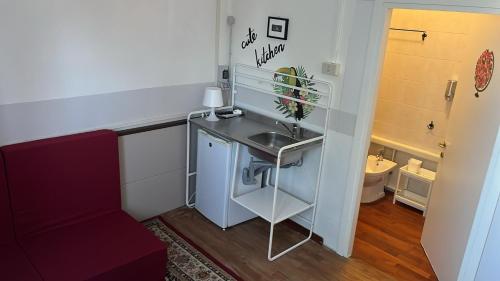 a small bathroom with a sink and a red couch at Il Cielo di Lucio in Pisa