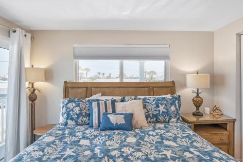a bedroom with a bed with blue and white pillows at A Beach Retreat on Casey Key in Venice