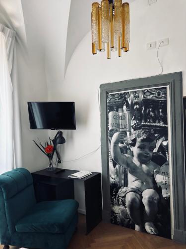 a living room with a blue chair and a mirror at Stanze di Agatha in Catania