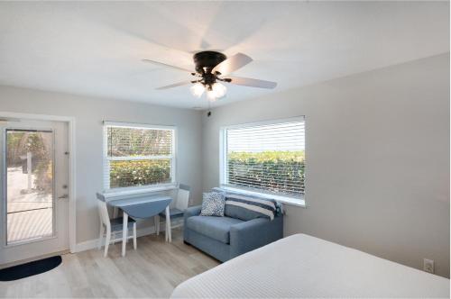 a bedroom with a ceiling fan and a chair and a desk at A Beach Retreat on Casey Key in Venice