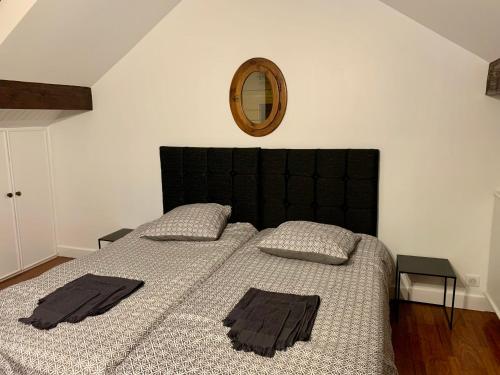 Un dormitorio con una cama con cabecero negro y un espejo. en La glam house, en Saint-Denis