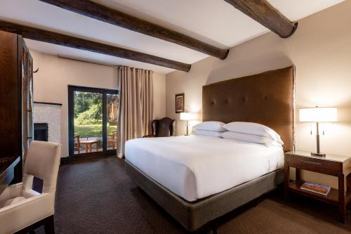 a bedroom with a large white bed and a fireplace at El Monte Sagrado Resort & Spa in Taos