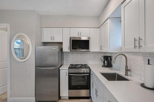 a kitchen with white cabinets and a stainless steel refrigerator at A Beach Retreat on Casey Key in Venice