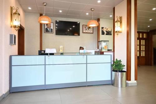 a reception desk in a hospital with a tv on the wall at Grand Hôtel City - Akwa in Douala
