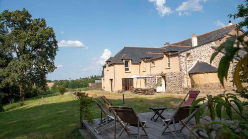 un groupe de chaises assises sur une terrasse devant une maison dans l'établissement La Hulotte- Brocéliande, à Saint-Malon-sur-Mel