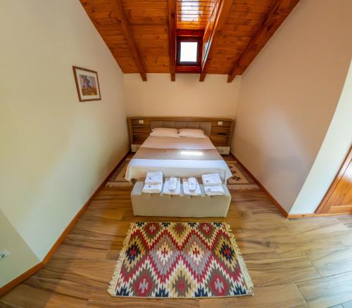 a room with two beds and a rug on the floor at Sofra Kelmendit in Tamarë