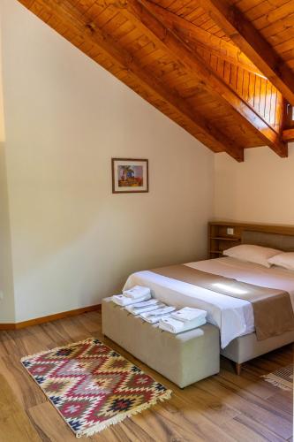 a bedroom with two beds and a wooden ceiling at Sofra Kelmendit in Tamarë