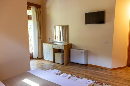 a bedroom with a bed and a television on the wall at Sofra Kelmendit in Tamarë