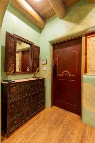 a bathroom with a wooden door and a mirror at El Monte Sagrado Resort & Spa in Taos