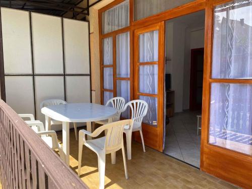 a porch with a table and chairs on a balcony at Holiday home in Balatonmariafürdo 19477 in Balatonmáriafürdő