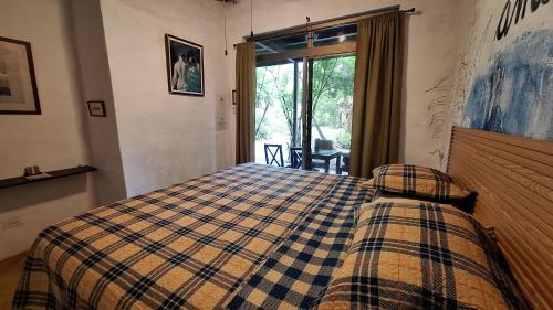 a bedroom with a bed with a checkered blanket at The Blue House Panama in Chame
