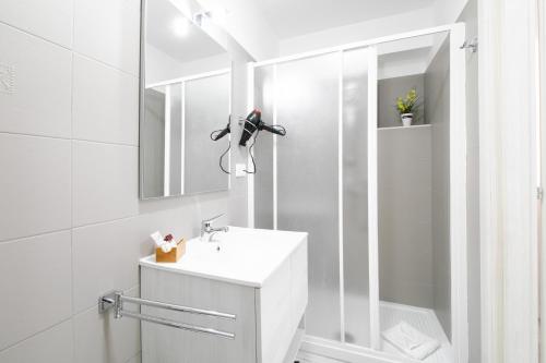 a white bathroom with a sink and a mirror at NICOLE LUXURY ROOMS in Fondi