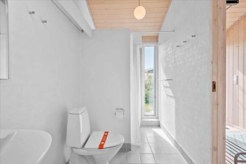 a white bathroom with a toilet and a sink at 1060-Stege-Ulvshalevej-213 in Stege