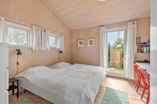 a bedroom with a bed in a room with windows at 1060-Stege-Ulvshalevej-213 in Stege