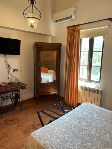 a bedroom with a bed and a desk and a window at Casa Rural La Calera in San Millán de la Cogolla