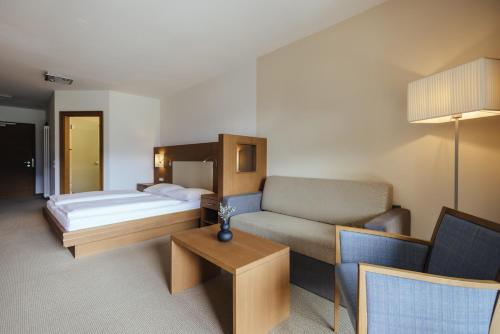 a hotel room with a bed and a couch at Hilburger Hotel in Schenna