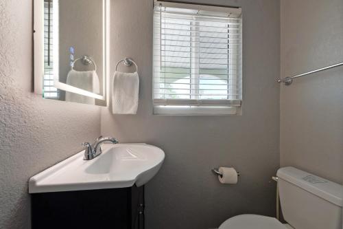 a bathroom with a sink and a toilet and a mirror at A Beach Retreat on Casey Key in Venice