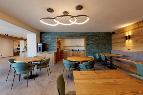 a restaurant with wooden tables and blue chairs at Oltre Alpine Hotel in Bormio