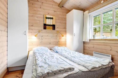 a bedroom with two beds in a room with wooden walls at 1117-Stege-Kristtjornvej-27 in Stege