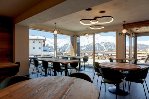 a restaurant with tables and chairs and mountains at Oltre Alpine Hotel in Bormio