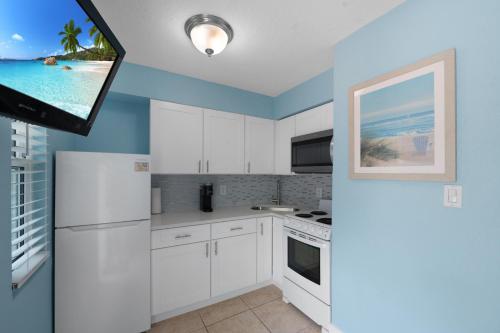 a kitchen with white appliances and a flat screen tv at A Beach Retreat on Casey Key in Venice