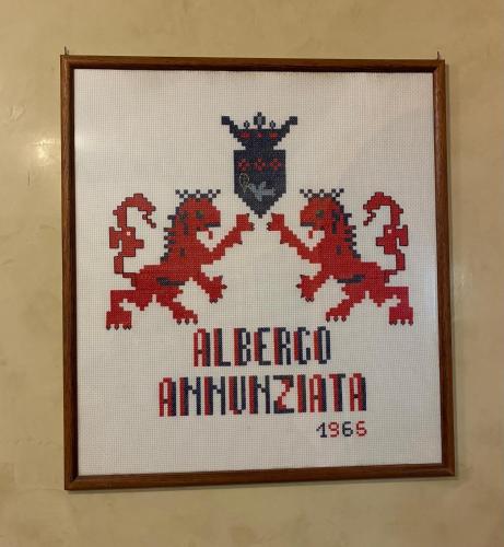 a cross stitch picture of two dragons on a wall at Hotel Annunziata in Massa