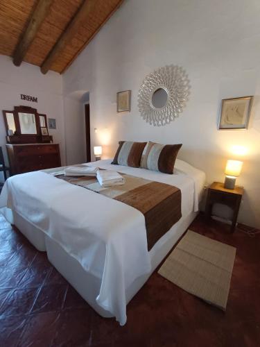 a large white bed in a bedroom with two lamps at Monte Costa Raiz in Mértola