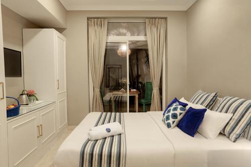 a bedroom with a large bed with blue and white pillows at Oceansuite hotel Goa in Orxel
