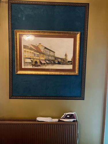 a framed painting of a building on a wall at Classic Love Story in Old Cluj II in Cluj-Napoca