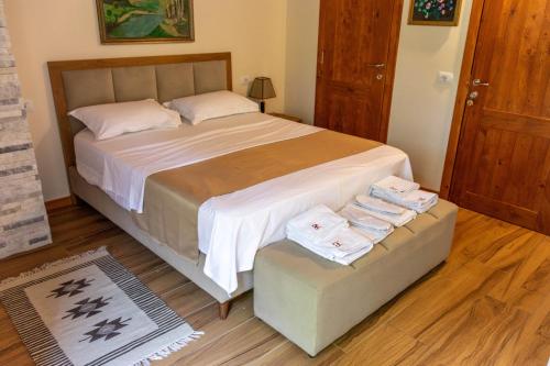 a bedroom with a large bed with two folded towels at Sofra Kelmendit in Tamarë