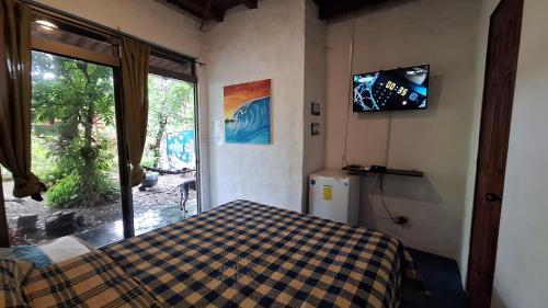 a bedroom with a bed and a tv on the wall at The Blue House Panama in Chame