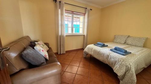 a living room with a couch and a bed at Toca dos Coelhos in Silveira