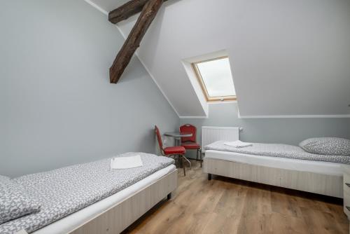 ein Zimmer mit zwei Betten und einem Fenster in der Unterkunft Pensjonat BONI in Tolkmicko