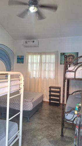 a bedroom with two bunk beds and a ceiling fan at The Blue House Panama in Chame