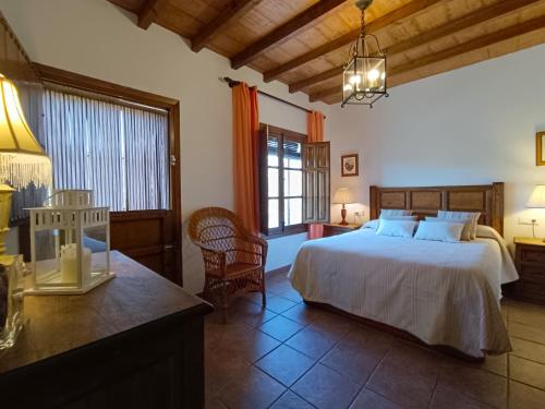 Un dormitorio con una cama grande y una mesa y sillas. en Villa del Sol, en Frigiliana
