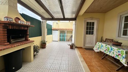 a patio with a fireplace and a table in a room at Toca dos Coelhos in Silveira
