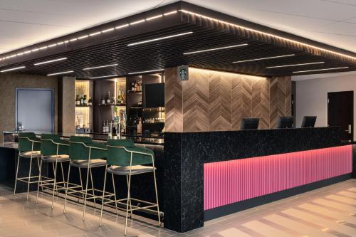 a bar with green bar stools in a restaurant at Hyatt Place Charlotte Downtown in Charlotte