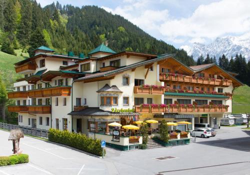 a hotel in the mountains with a parking lot at Hotel Lärchenhof in Lermoos