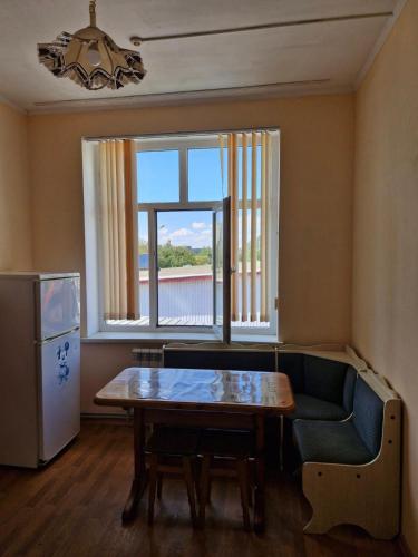 a living room with a table and a couch and a window at Арривато in Chornomorsk