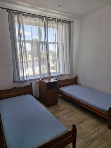 a room with two beds and a window at Арривато in Chornomorsk