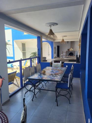 a dining room with a table and chairs on a balcony at Riad Ghazal in Essaouira