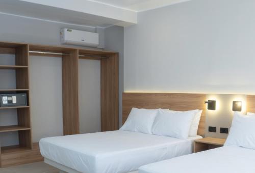 two beds in a hotel room with white sheets at Senoma Hotel - Adults only in Ica