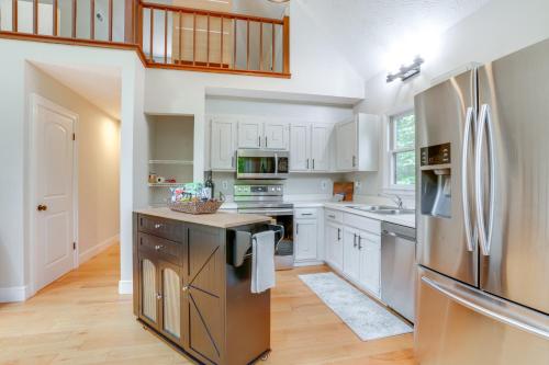 a kitchen with white cabinets and a stainless steel refrigerator at Pet-Friendly Lake Monticello Home with Perks! in Zion Crossroads