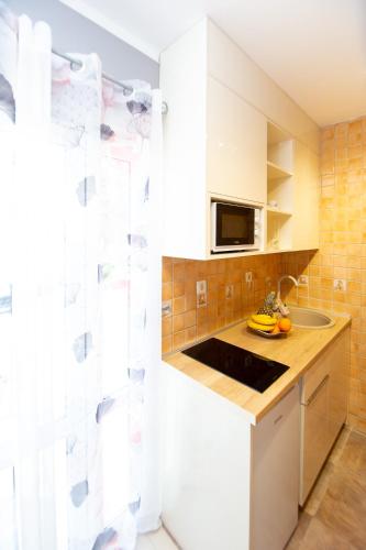 a kitchen with a sink and a microwave at ACIKA apartments in Rafailovici