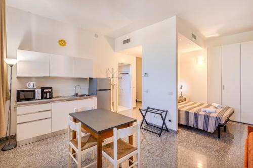 a kitchen with white cabinets and a table and a bed at Via Moro - Home 47 in Quarto dʼAltino