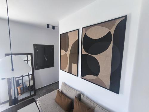 a living room with two large paintings on the wall at Koniko Santorini Private Pool Villas in Santorini
